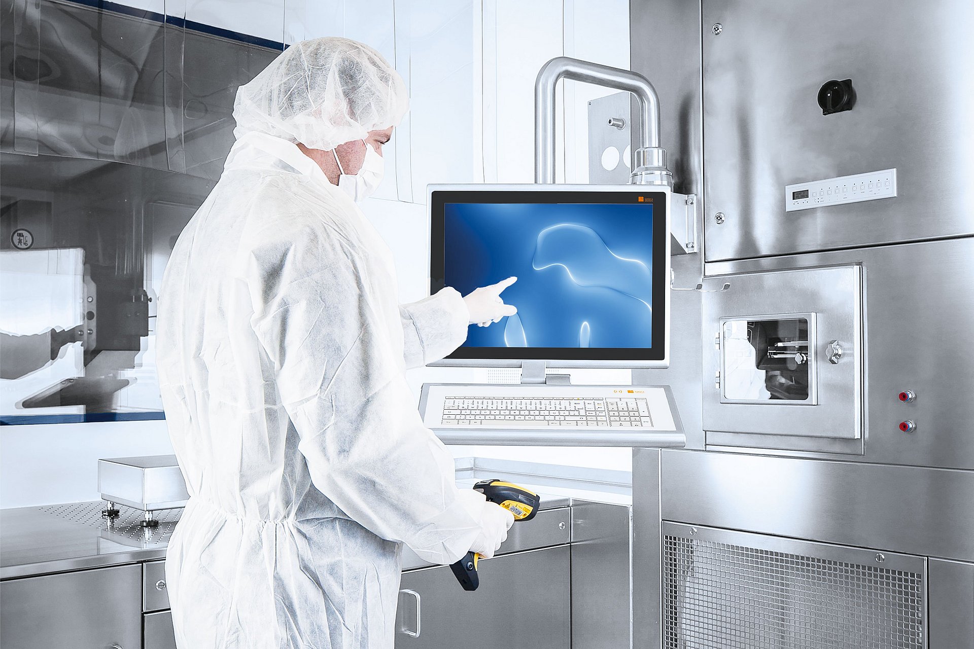 Employees in laboratory clothing with head and mouth protection work on the support-arm-mounted HMI system in cleanroom environment